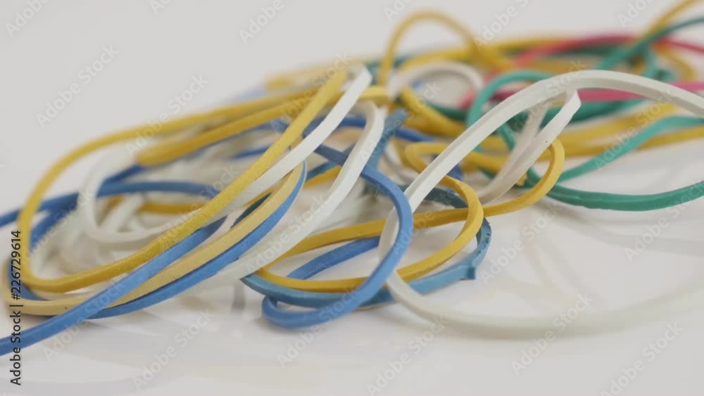 Pile of ring shaped rubber bands on white 4K panning video Pile of ring shaped rubber bands on white 4K panning video