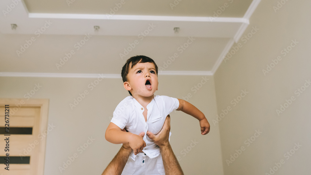 cropped shot of father carrying little son in hands