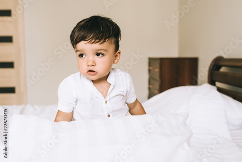 close-up portrait of adorable little child sitting on bed