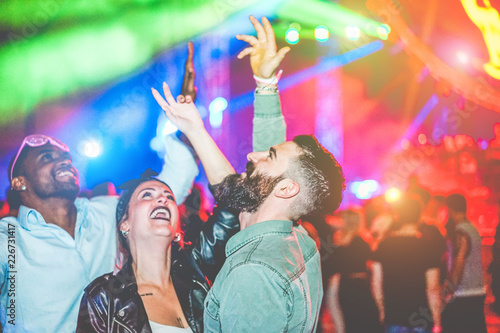 Crazy millennials friends dancing with laser lights in night club