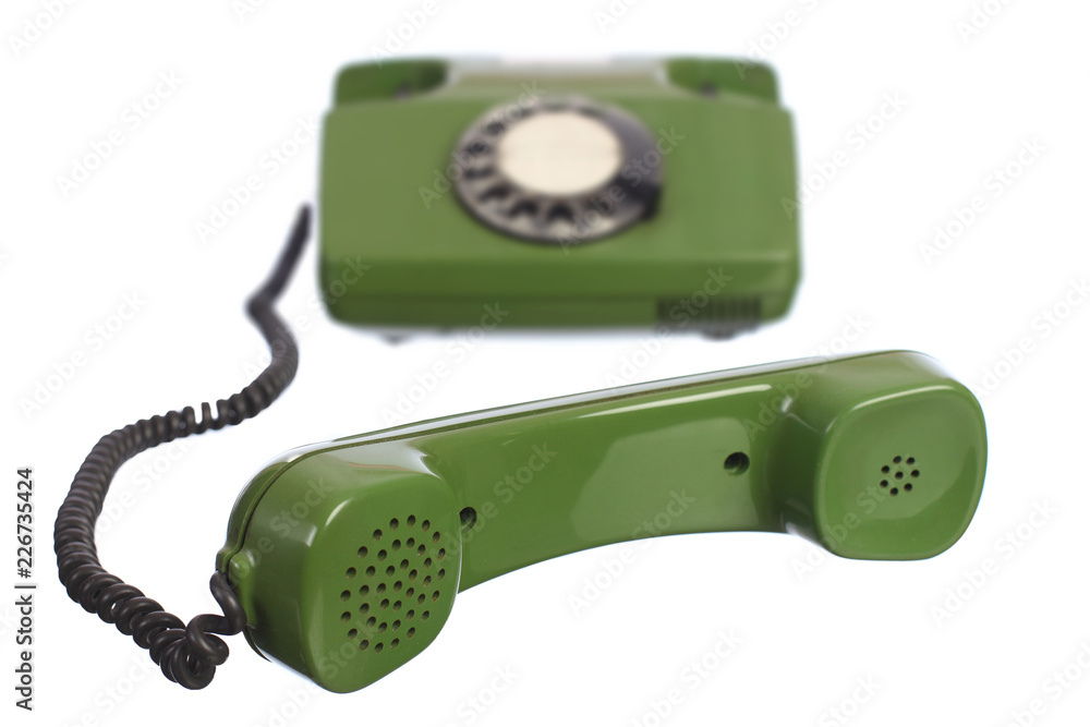 Green telephone set with handset off lying in front Green telephone set with handset off lying in front