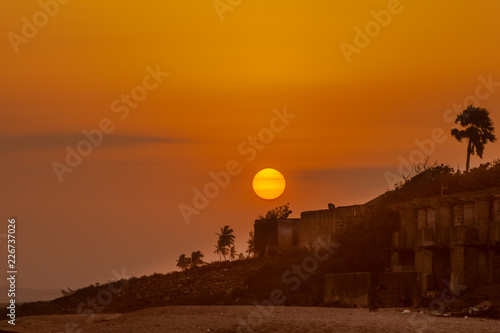 Bright orange sun setting over the beach of Cape Coast, Ghana