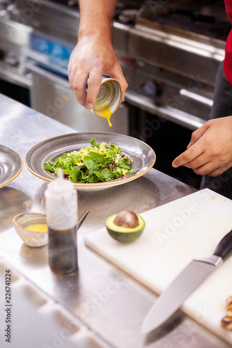 Chef seasoning salade with lemon juice ,Delicious fresh food