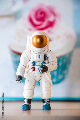 Toy figure of an astronaut, in the background of a cake