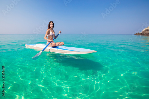 Young attractive woman in the sea on the Stand Up Paddle Board. SUP. Healthy lifestyle.