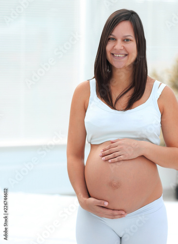 portrait of young pregnant woman on a light background.