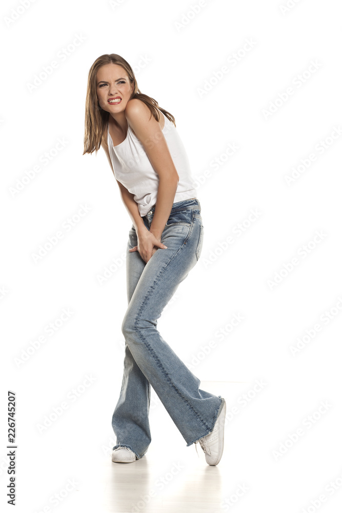 Unappy young pretty woman needs a toilet on white background Unappy young pretty woman needs a toilet on white background