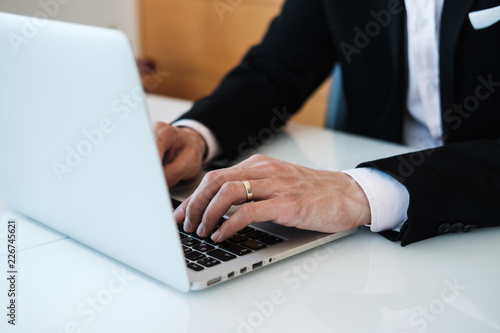 Businessman typing on laptop at office. Concept of using technology for work. Horizontal.