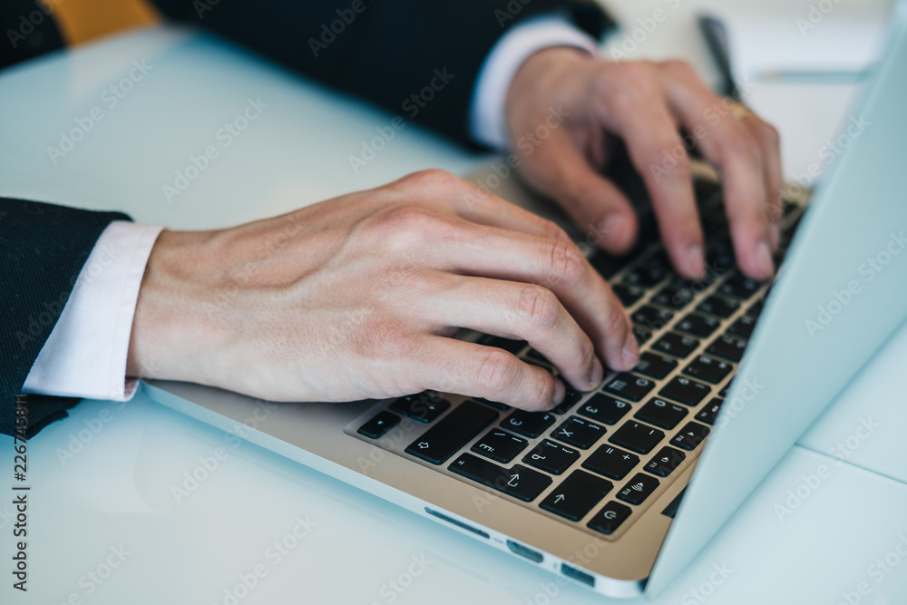 Close-up of businessman's hands typing on keyboard of laptop. Concept of using modern technology for work in office. Horizontal. Close-up of businessman's hands typing on keyboard of laptop. Concept of using modern technology for work in office. Horizontal.