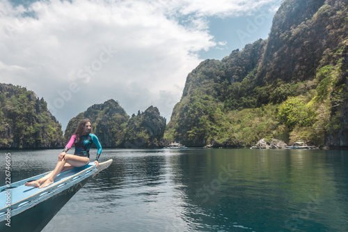 Woman relaxing on the boat and looking forward into lagoon. Travelling tour in Asia  El Nido  Palawan  Philippines.