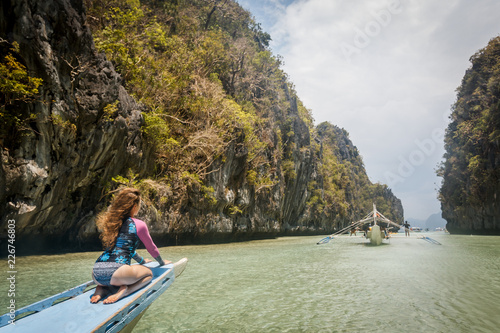 Woman relaxing on the boat and looking forward into lagoon. Travelling tour in Asia: El Nido, Palawan, Philippines. © Sokirlov