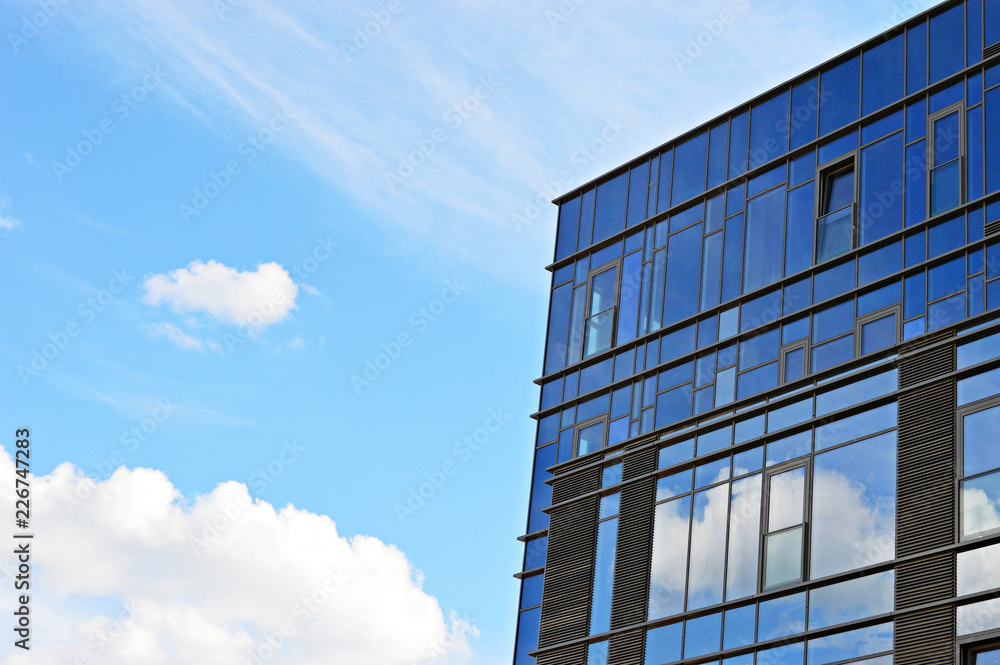 Glass office building against blue sky