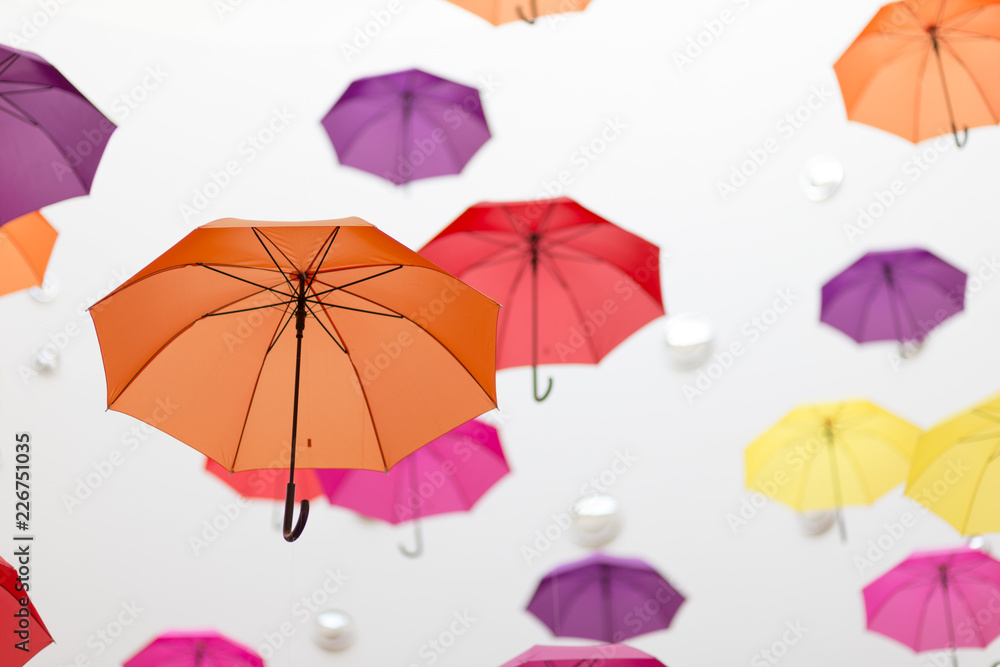 Conceptual installation of abstract background of beautiful colored umbrellas indoors.