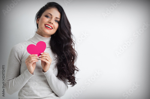 Woman holding pink paper heart