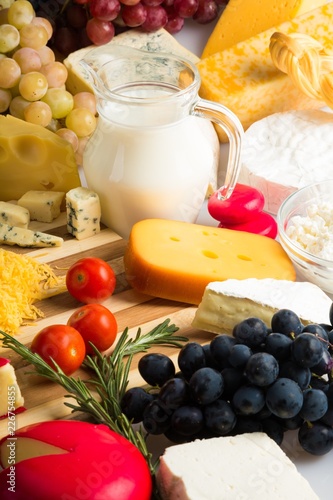 Cheeses, Grapes, Cherry Tomatoes and Milk on the Wooden Platter