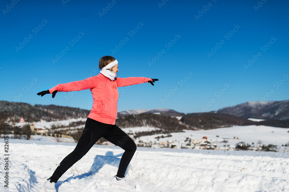 Senior woman runner stretching in winter nature. Copy space. Senior woman runner stretching in winter nature. Copy space.