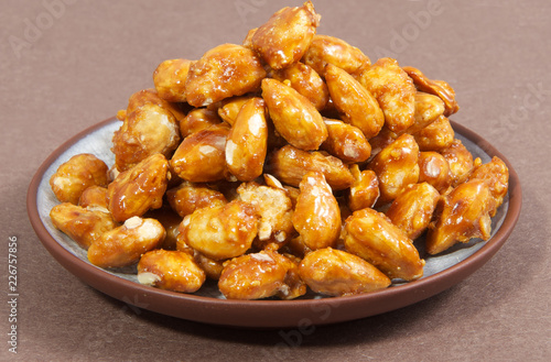 Nuts on a plate on a brown background