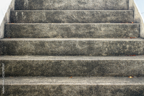 Abstract background of concrete stairway. Surface of cement stair with small stone. Grunge texture of outdoor staircase. Low angle view step of stairs.