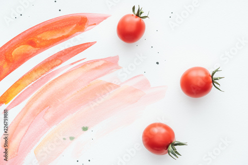 top view of delicious cherry tomatoes on white surface with red watercolor strokes