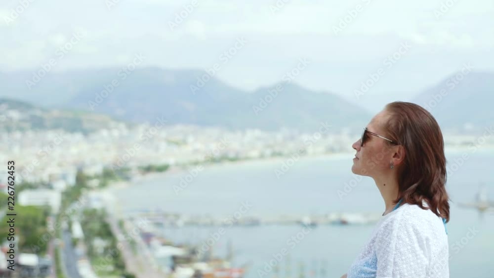 A female tourist admires the beautiful scenery. View of the city from a height. A female tourist admires the beautiful scenery. View of the city from a height.