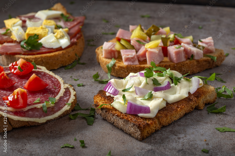 Set of open sandwiches with boiled eggs, cucumbers, salami, cheese and smoked meat