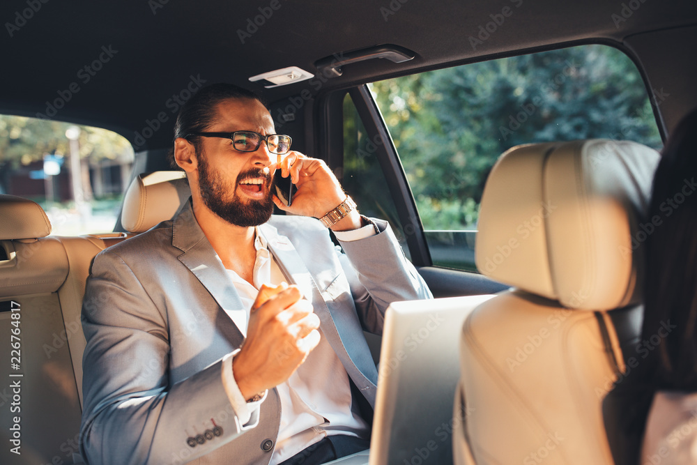 Businessman talking on the phone in a taxi Businessman talking on the phone in a taxi