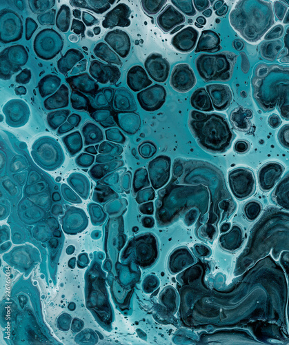 Beautiful textural background. Paint sea green flowing in purple with the addition of black and white paint. The style includes curls of marble or agate ripples with bubbles and cells. Natural suite.