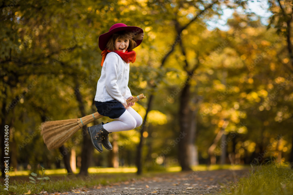 Ταπετσαρία Funny little girl flies on broom in autumn park