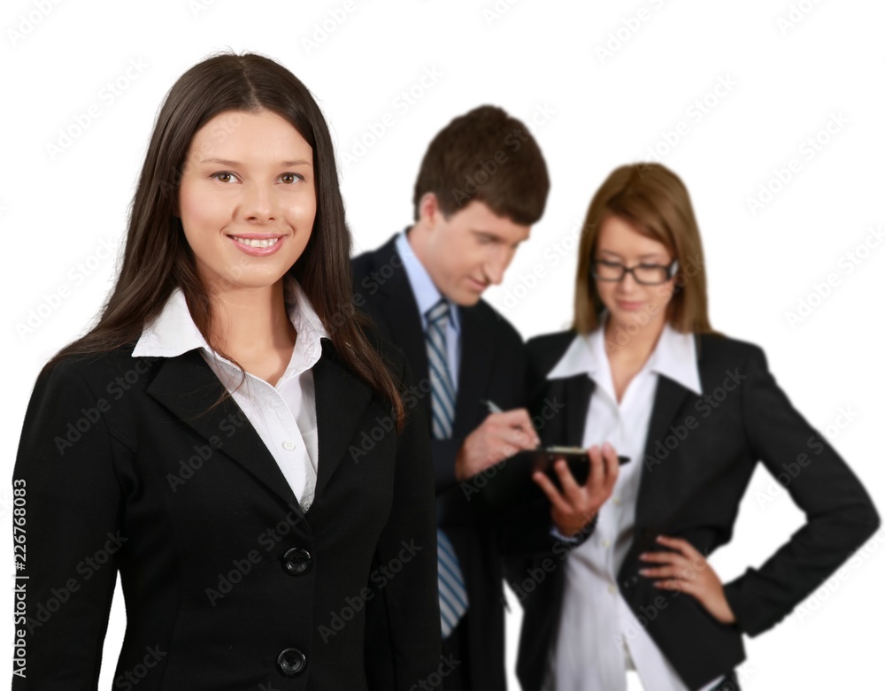 Friendly Businesswoman and Talking Collaborators in Background - Friendly Businesswoman and Talking Collaborators in Background -