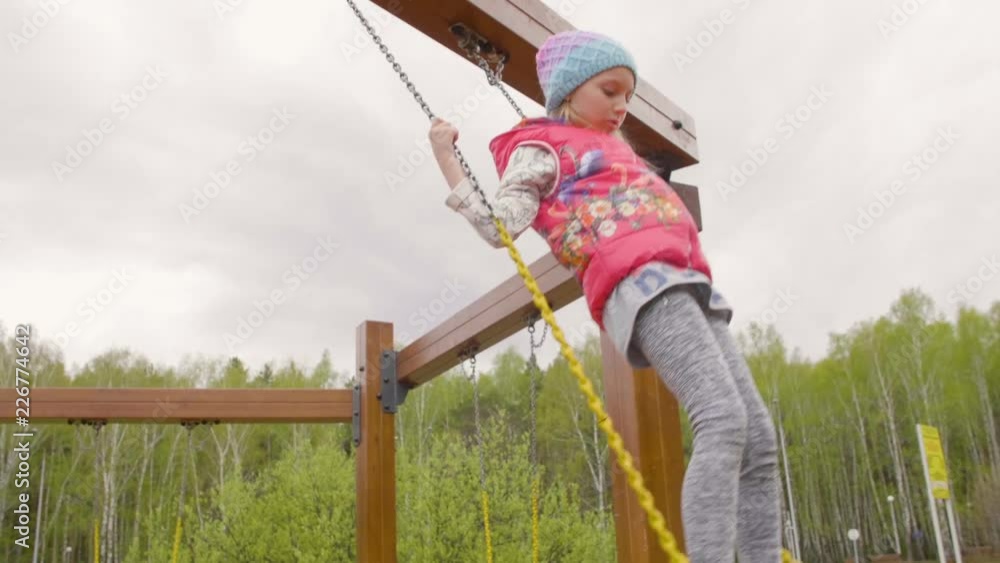 Standing teenager girl swinging at spring day in city park slow motion Standing teenager girl swinging at spring day in city park slow motion
