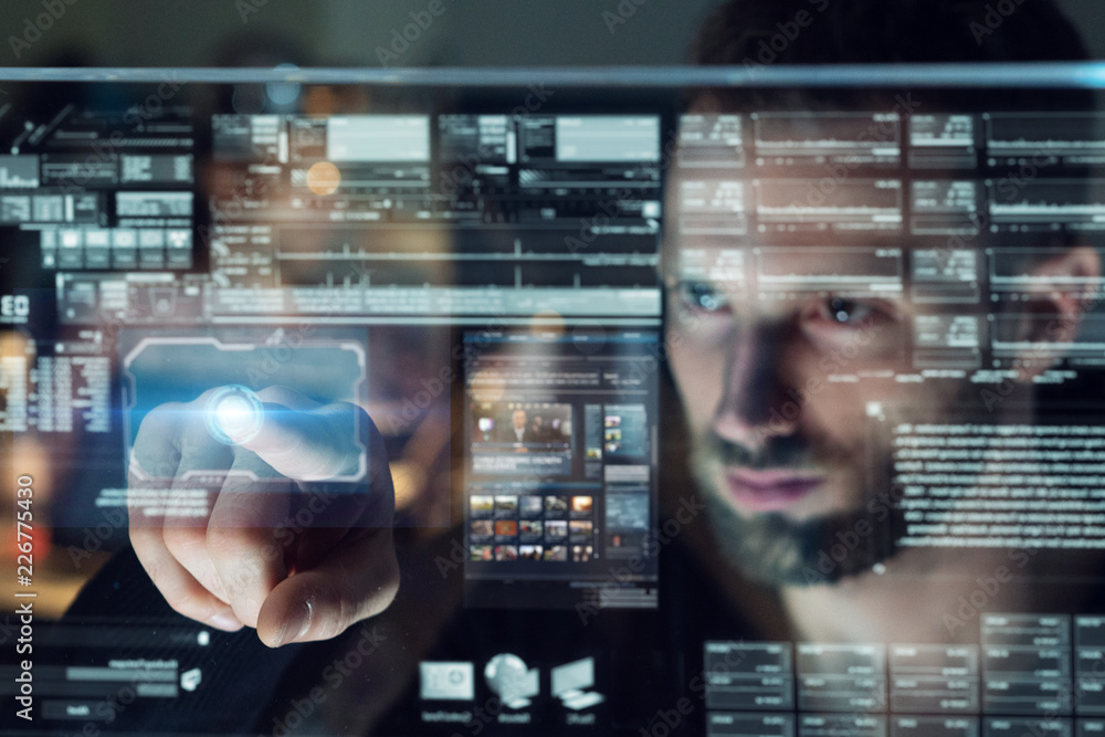 Portrait of a young man (boy) while he is using a futuristic computer with holograms. Concept: Future, technology, work Portrait of a young man (boy) while he is using a futuristic computer with holograms. Concept: Future, technology, work