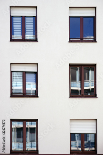 Spieglungen in den Fenstern eines Wohngebäudes / Die Fassade eines Wohngebäudes mit Fenstern in denen sich die Umgebung spiegelt. ..