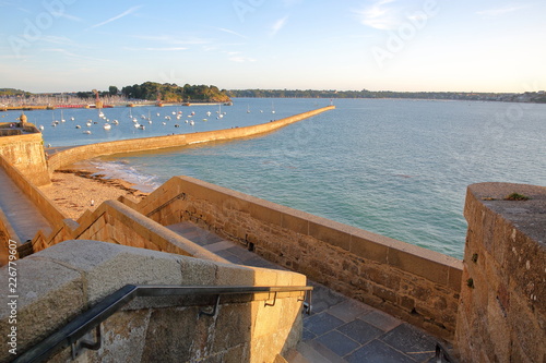 Obraz na plátně The ramparts of the walled city of Saint Malo at sunset, with the pier (Mole des
