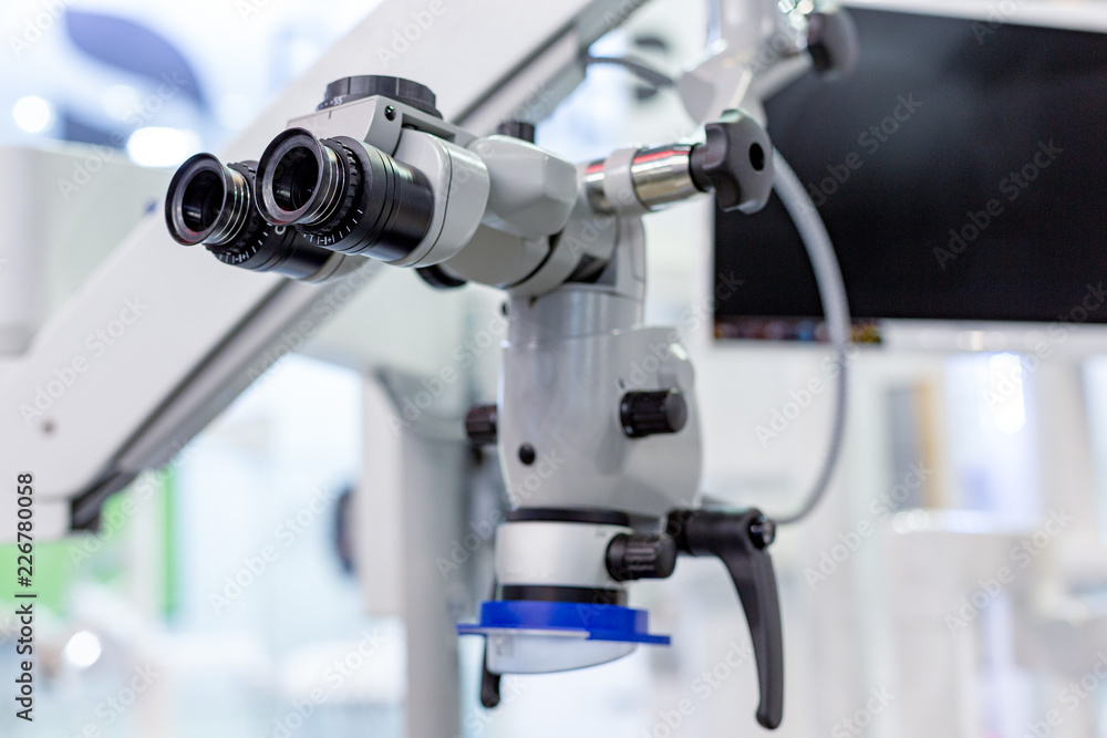 Dental microscope on the background of modern dentistry. Medical equipment. Dental operating microscope with rotary double binocular. Dental microscope on the background of modern dentistry. Medical equipment. Dental operating microscope with rotary double binocular.