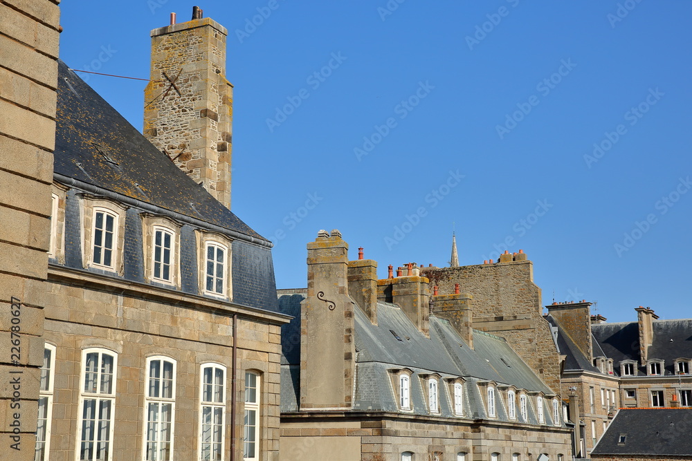 Traditional house facades with chimneys and roofs, located inside the walled city and viewed from the ramparts, Saint Malo, Brittany, France