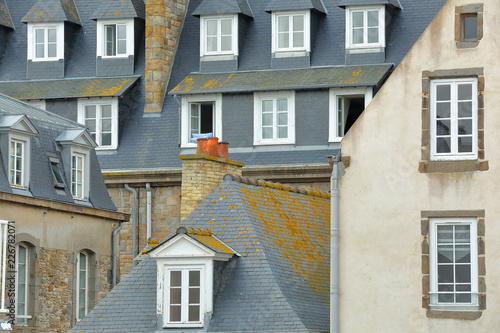 Close-up on traditional house facades with chimneys and roofs, located inside the walled city of Saint Malo, Brittany, France