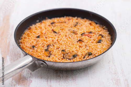 rice with seafood in dish on white background