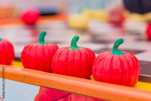 three plastic red pumpkins in a row, perpspective view, selective focus photo