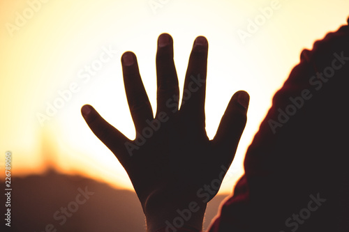 Silhouette of hand against sunset