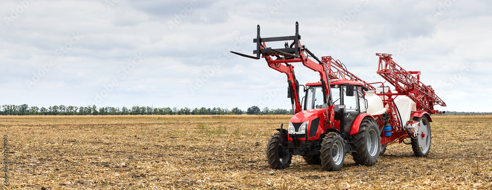 Fototapeta premium Tractor with a sprayer for agricultural chemistry with a field