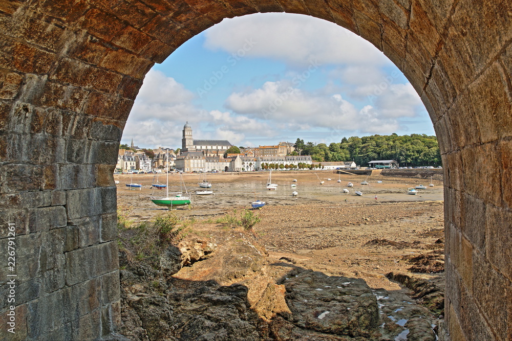 The beach Solidor at Saint Servan at low tide viewed through an archway, with Sainte Croix Church in the background, Saint Malo, Brittany, France