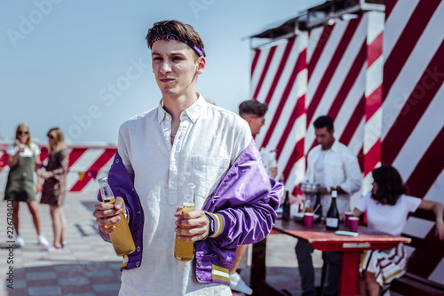 Want to drink. Concentrated student standing on the foreground and looking for his partner