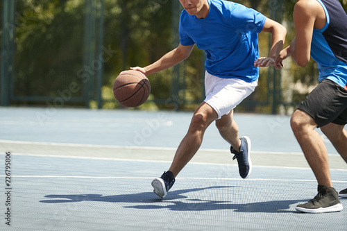 Fotografia young asian adults playing basketball