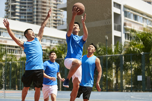 young asian adults playing basketball photo