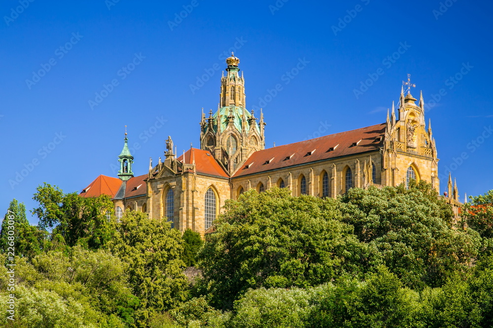Monumental monastery of Benedictines in Kladruby, Czech Republic, Europe from 12th century standing on hill, includes church of All Saints, red roof, green foreground, sunny summer day, blue sky