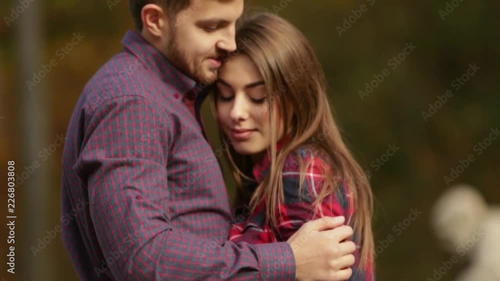 Man and woman walking in the park in autumn weather Man and woman walking in the park in autumn weather
