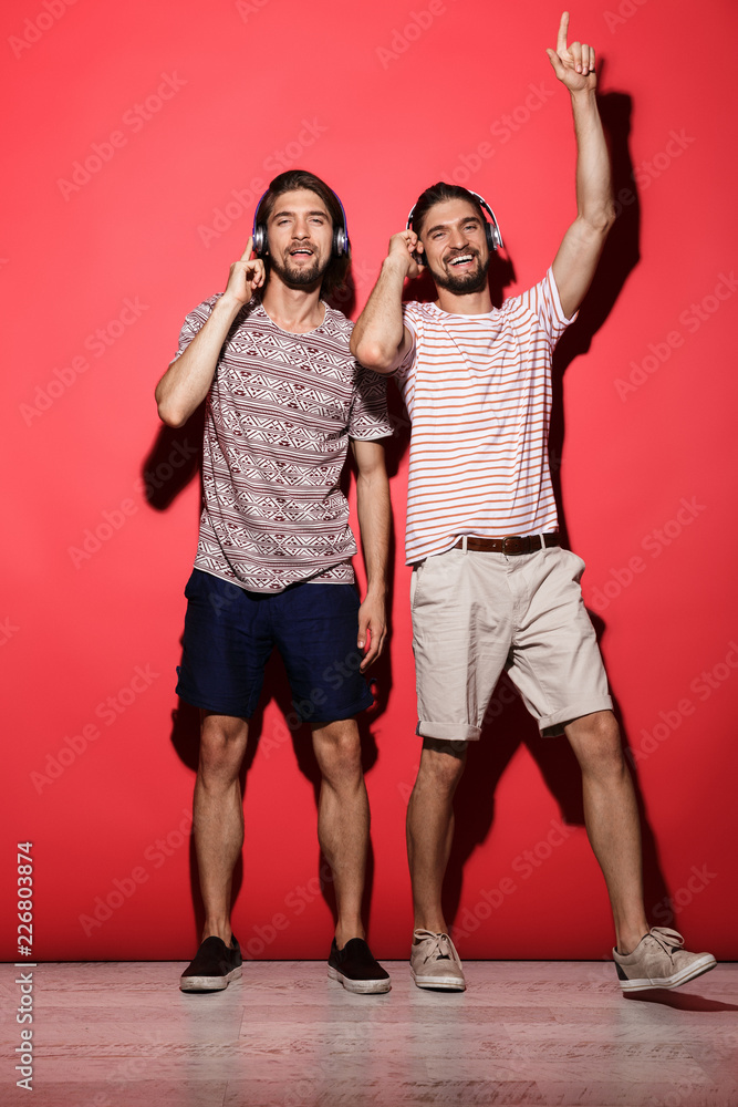 Fototapeta premium Full length portrait of a two young cheerful twin brothers