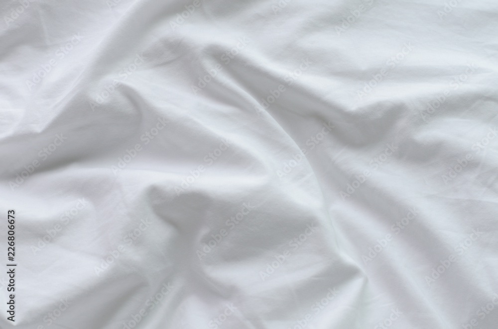 Top view of messy white color bed sheet texture background.
