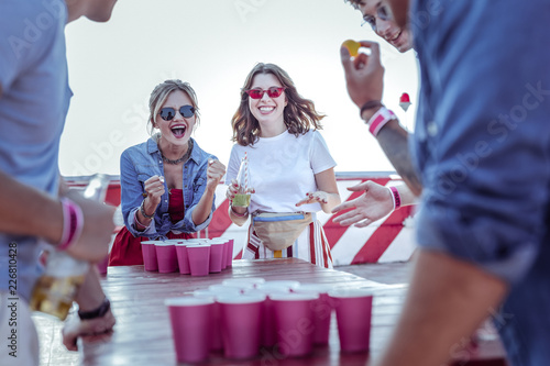 Hurray. Cheerful brunette keeping smile on her face while enjoying friendly atmosphere photo