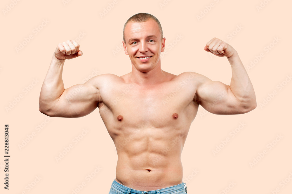 Fitness muscular man showing six pack on pastel background
